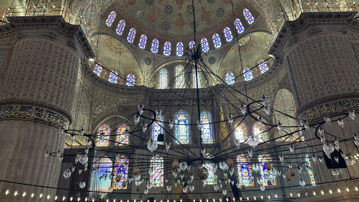 スルタンアフメト・モスク(ブルーモスク)内部の礼拝空間。ステンドグラスとシャンデリアが美しいドーム下の眺め